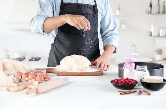 Men Sprinkling flowers over the dough