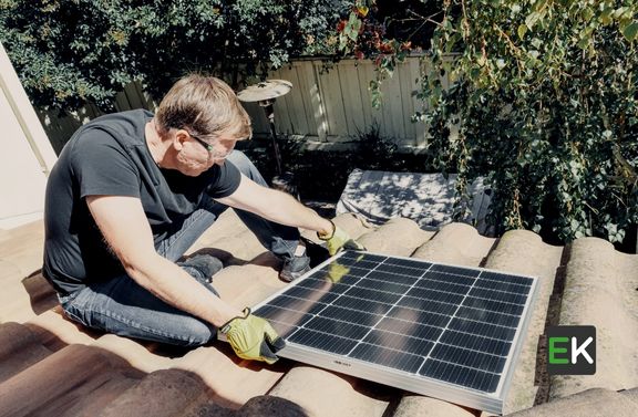 Person installing a Solar Panel on his house's rooftop 