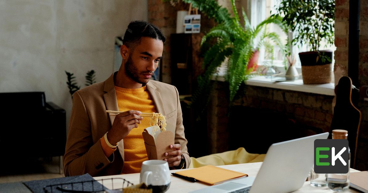 Men working on a desktop while eating