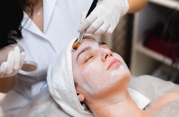 Beautician applying face mask